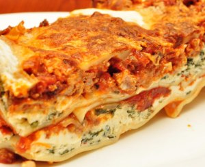 A slice of lasagana on a plate.